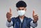 Youre making a difference. a male nurse showing thumbs up while wearing a surgical mask.