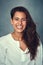 Youre never fully dressed without a smile. Portrait of a beautiful young woman smiling against a gray background in