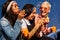 Youre never too old to blow bubbles. three attractive young women sitting against a blue wall together and bonding by