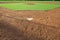 A youth baseball field viewed from home plate in morning light