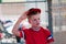 Youth baseball player taking hat off in dugout.