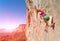 Youth female Rock Climber hanging on vertical Wall