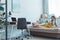 youth girl reading book on sofa in room with laptop