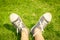 Youth sneakers on girl legs on grass