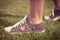 Youth sneakers on girl legs on grass