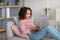 Youth and technology. Black girl using laptop and typing on keyboard, sitting on comfortable couch