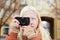 Youthful albino girl with long blond hair photographing something