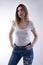 Youthful Confidence: Vertical Studio Portrait of a Beautiful Blonde Student Woman in White T-Shirt and Blue Jeans