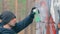 Youthful Guy Drawing Graffiti Using Spray Paint Can