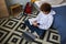 Youthful schoolboy in hoodie and classic jeans using mobile phone