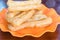 Youtiao or Asian doughnut in orange plate on wooden table close-up