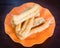 Youtiao or Asian doughnut in orange plate on wooden table close-up