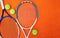 Youve met your match. High angle shot of tennis essentials placed on top of an orange background inside of a studio.