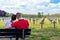 Ysselsteyn, Netherlands - May 23, 2019. A pair of young people sitting on a bench looking at concrete crosses at the German war ce