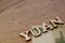 yuan word concept made of wooden letters on wooden background with Chinese flag