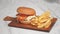 Yummy big cheeseburger with juicy cutlet in wooden tray. Fast food set, hamburger and French fries. woman eat hamburger