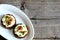 Yummy canape with soft cheese and chanterelle mushrooms on a plate on a wooden background