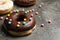 Yummy donuts with colorful sprinkles on background, space for text