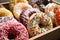 Yummy donuts with sprinkles in box, closeup