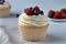 Yummy luxury vanilla mousse cupcake whipped cream icing decorated fresh berries raspberry blueberry topping fruit cake