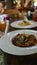 Yummy pasta on cafe table. Close-up of a plate with a portion of delicious pasta with minced meat, put on the table in a