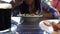 Yummy pasta on cafe table. Close-up of a woman eating a serving of delicious pasta with cream sauce on a table in a