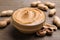 Yummy peanut butter in glass bowl on wooden table, closeup