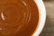 Yummy salted caramel in bowl on table, closeup