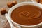 Yummy salted caramel in bowl on table, closeup