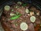 Yummy spicey mutton dish made with oil decorate with green chilies and lemons