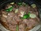 Yummy spicey mutton dish in plater made with oil decorate with green chilies and lemons