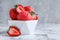 Yummy strawberry ice cream in bowl on white marble table. Space for text