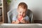 Yummy watermelon and little funny toddler in highchair. First feeding of child with watermelon