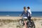 Yung couple biking on sandy dunes