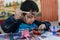 Yungay, Peru, August 4, 2014: portrait of happy naughty boy with paint stained face, clothes and hands doing crafts with brush