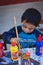 Yungay, Peru, August 4, 2014: portrait of happy naughty peruvian boy with face and clothes stained with paint doing crafts