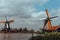 Zaanse Schans, Netherlands: Old dutch windmills in historical village filtered. Wooden windmills in field with river.