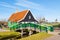 Zaanse Schans village, Holland, green houses and windmills against blue cloudy sky