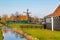 Zaanse Schans village, Holland, green houses and windmills against blue cloudy sky