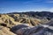 The Zabriskie Point lookout over a surreal landscape of undulating ridges of gold, orange, and brown earth in Death Valley