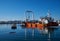 Zadar, Croatia, November 29, 2018. Leverage crane on barge lifting part of concrete pier being demolished and replaced