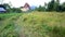 Zakopane, Poland: Tilt up shot of a grass field and a traditional wooden guest house against polish mountains from the South