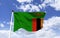 Zambia Flag Mockup, fluttering under a blue sky