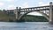 Zaporizhzhia, Ukraine - June 19, 2020: Tourist pleasure boat sails under a large old concrete bridge near view.