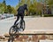 Zaragoza , Spain; 03 23 2019 : sport man wearing helmet, t-shirt, gloves and trousers in black riding a bmx bicycle getting up the