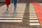 Zebra crossing with red bike lane and two people crossing