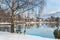 Zell am See in winter. View from Esplanade over Lake Zell to Prielau town. Idyllic scene with bank, birch tree, snow and