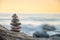 Zen balanced stones stacked on sea coast at sunset