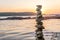 Zen balanced stones stacked on sea coast at sunset. Balance and equilibrium concept