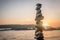 Zen balanced stones stacked on sea coast at sunset. Balance and equilibrium concept.